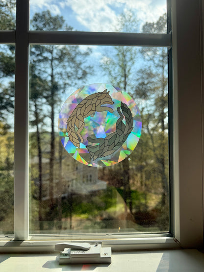 Holographic wolf design sticker on a window with outdoor view