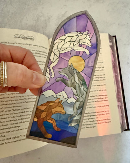 Decorative bookmark with Dire Bound wolf design in a stained glass style on an open book