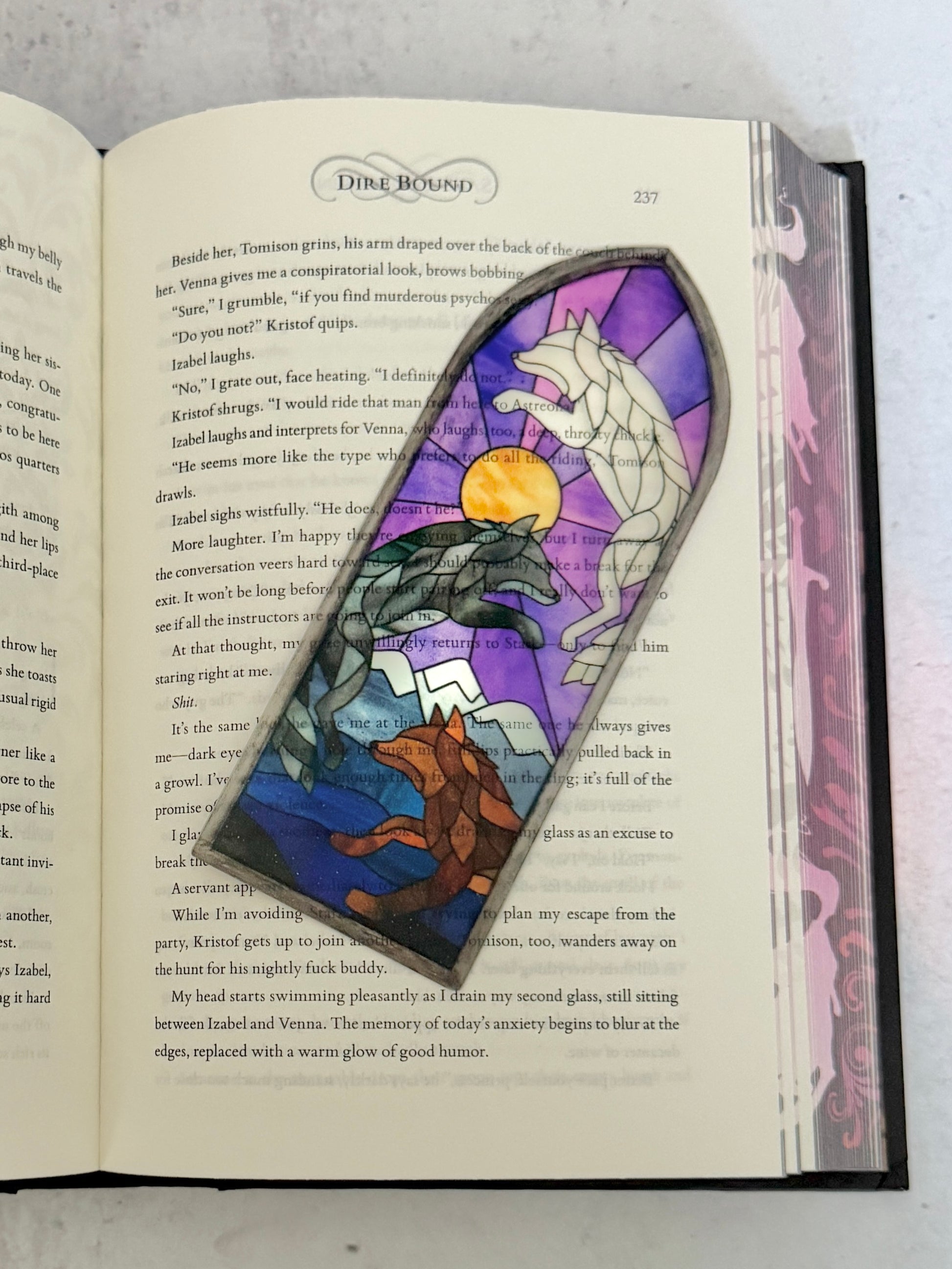 Stained glass-style bookmark with Dire Bound wolves on an open book