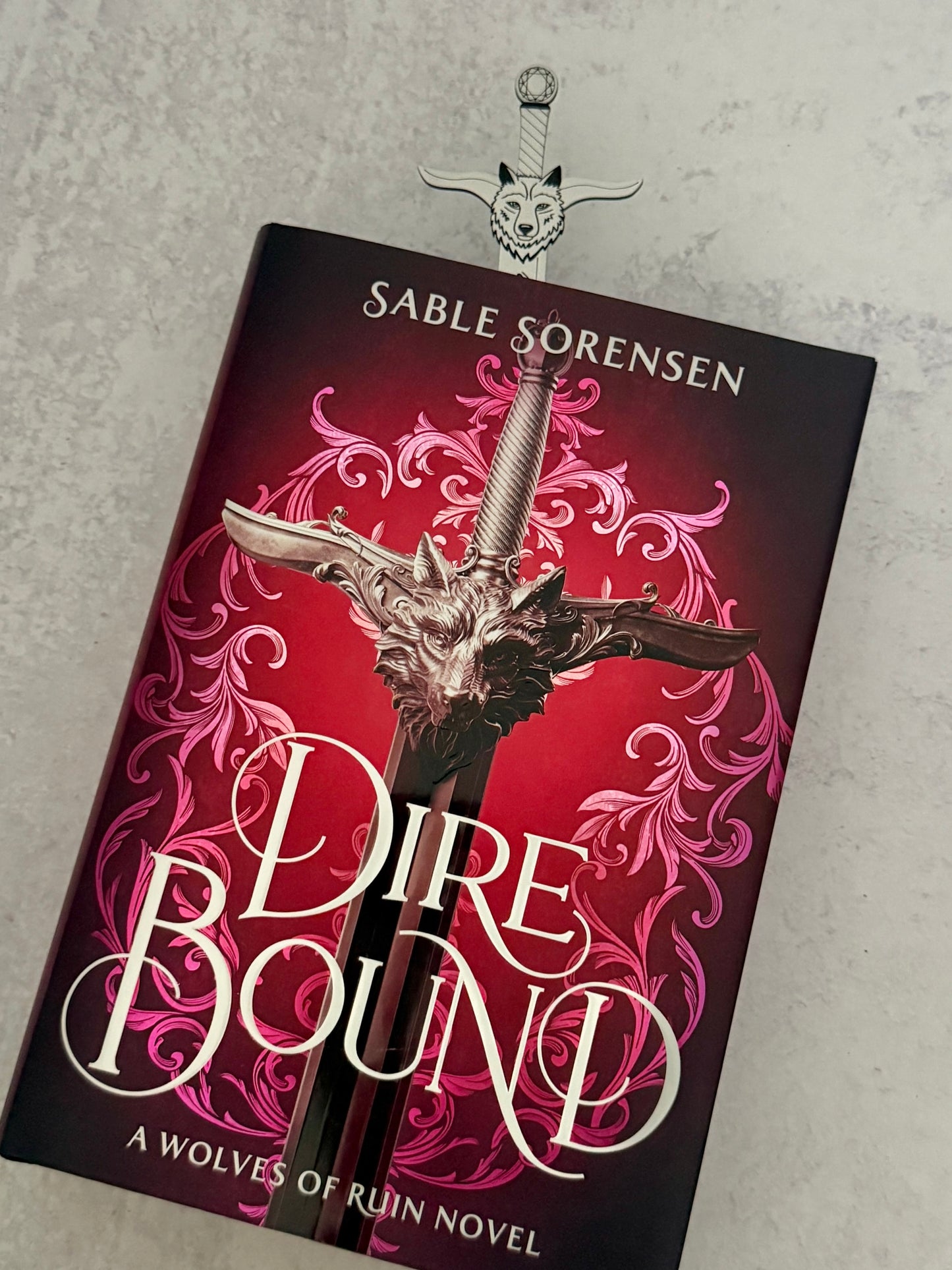 Book titled 'Dire Bound' by Sable Sorensen with a sword on a red background