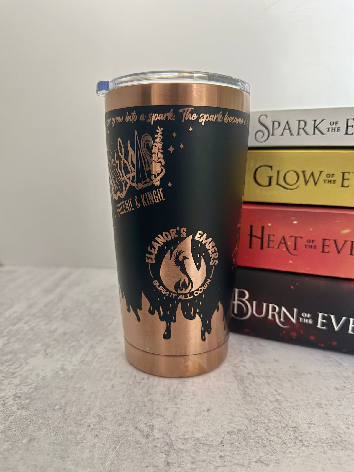 A black and copper Emarion 20 oz tumbler, showing the Queenie & Kingie and Eleanor's Embers designs from Burn of the Everflame by Penn Cole