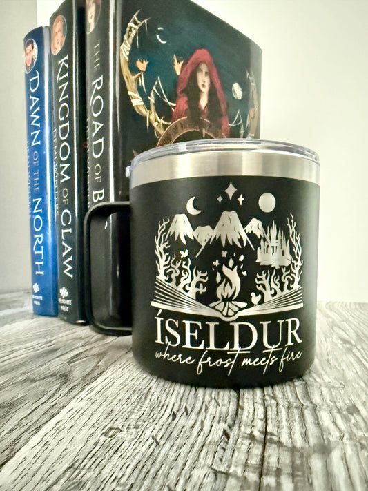 Black camp mug with 'Iseldur: where frost meets fire' bookish fantasy design, placed on a wooden surface with Demi Winters' Ashen series books in the background.