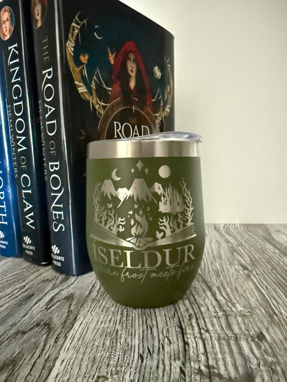 Olive green wine tumbler with 'Iseldur: where frost meets fire' bookish design in front of Demi Winters' The Road of Bones books on a wooden surface