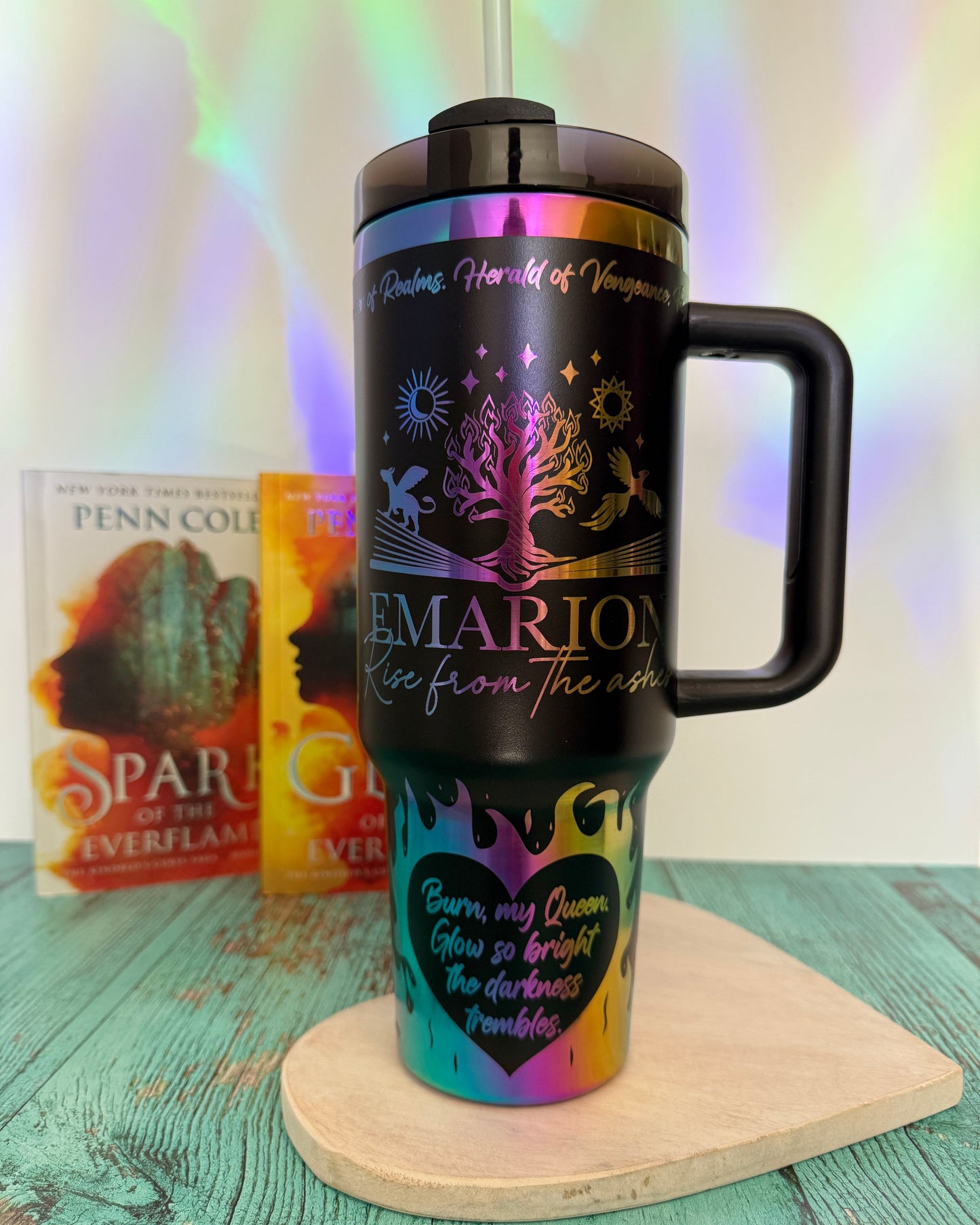 Black 40 oz tumbler with rainbow engrave design featuring Emarion, Rise from the ashes, the Everflame tree and fire along the bottom with the quote "Burn, my Queen. Glow so bright the darkness trembles."