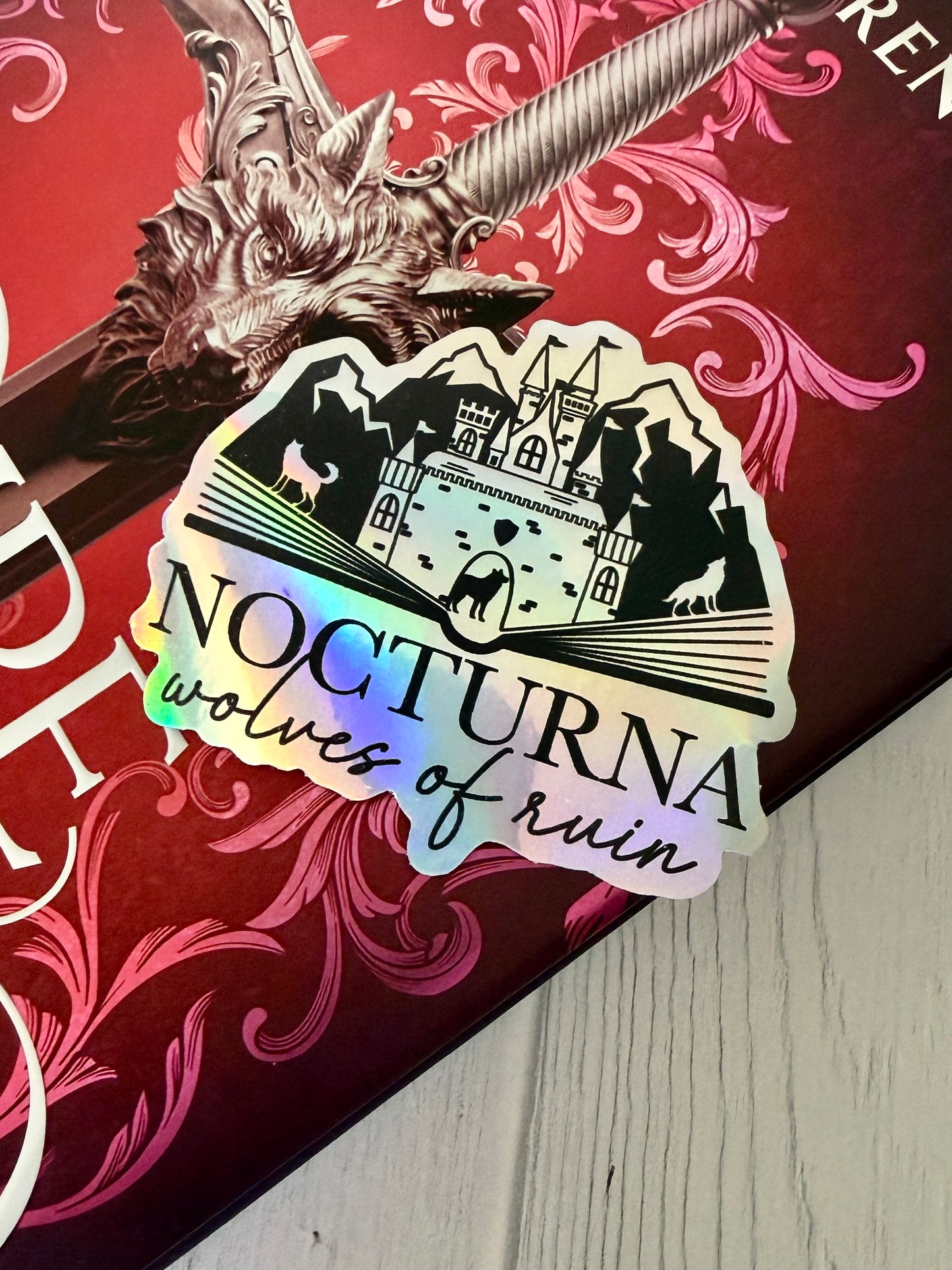 Sticker with 'Nocturna Wolves of Ruin' design on a Dire Bound book featuring the wolf head direblade.