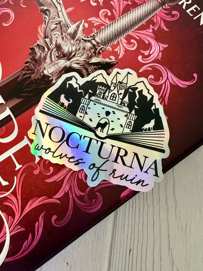 Sticker with 'Nocturna Wolves of Ruin' design on a Dire Bound book featuring the wolf head direblade.