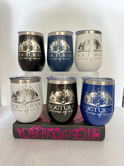 Set of six 'Nocturna' themed tumblers with a book titled 'Dire Bound' in the background.