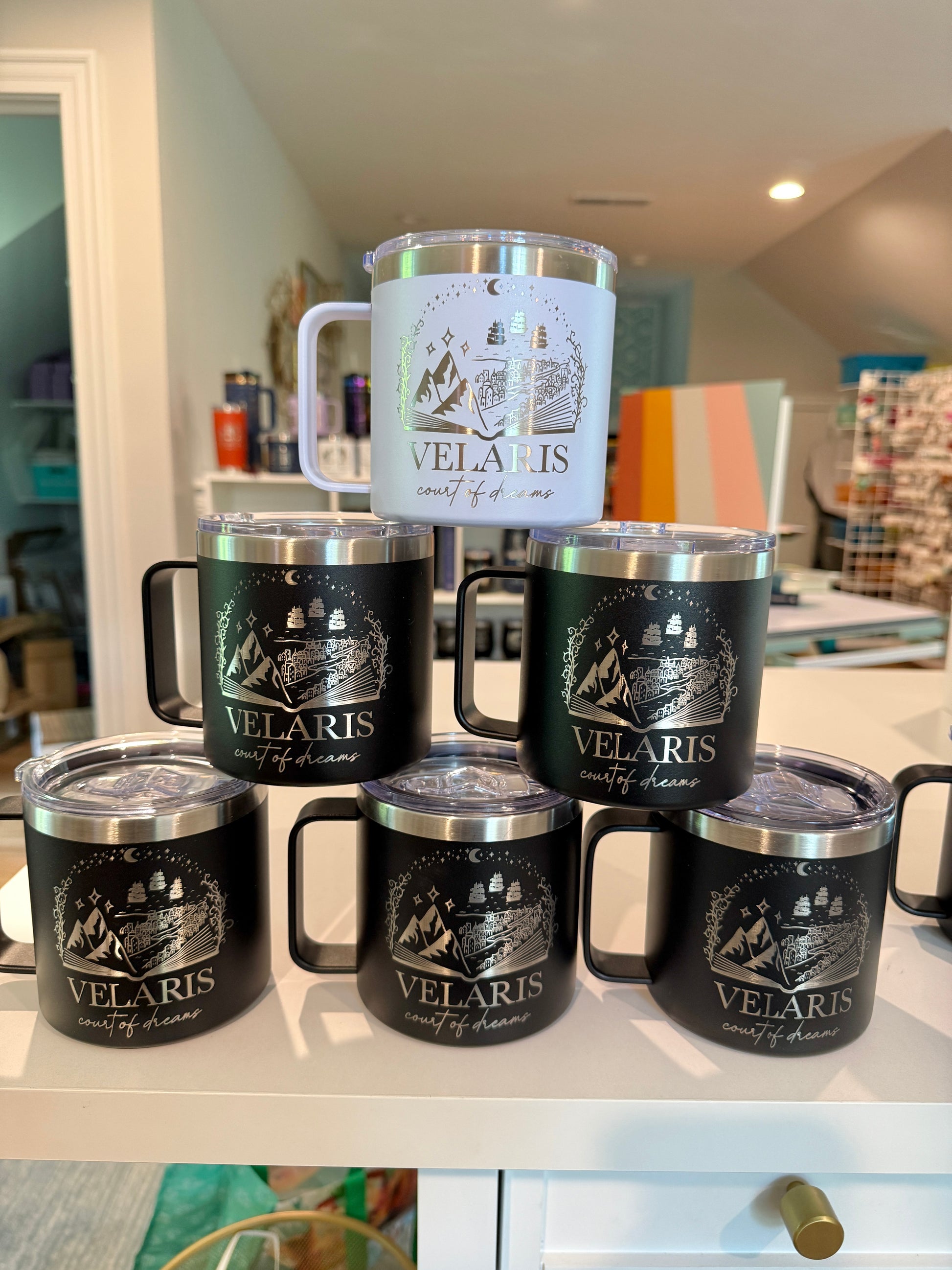 Collection of Velaris branded tumblers on a surface with a home interior background.