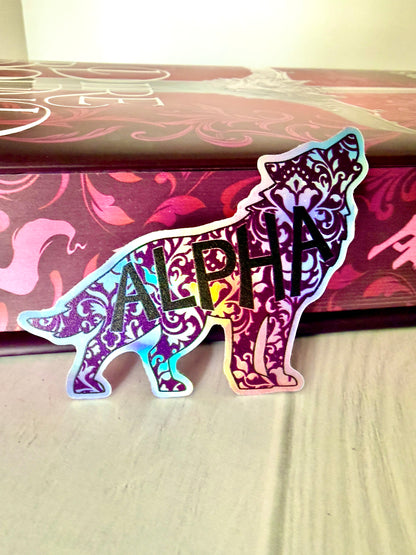 Decorative wolf shaped die cut holographic sticker with 'ALPHA' leaning against the sprayed edges of Dire Bound.
