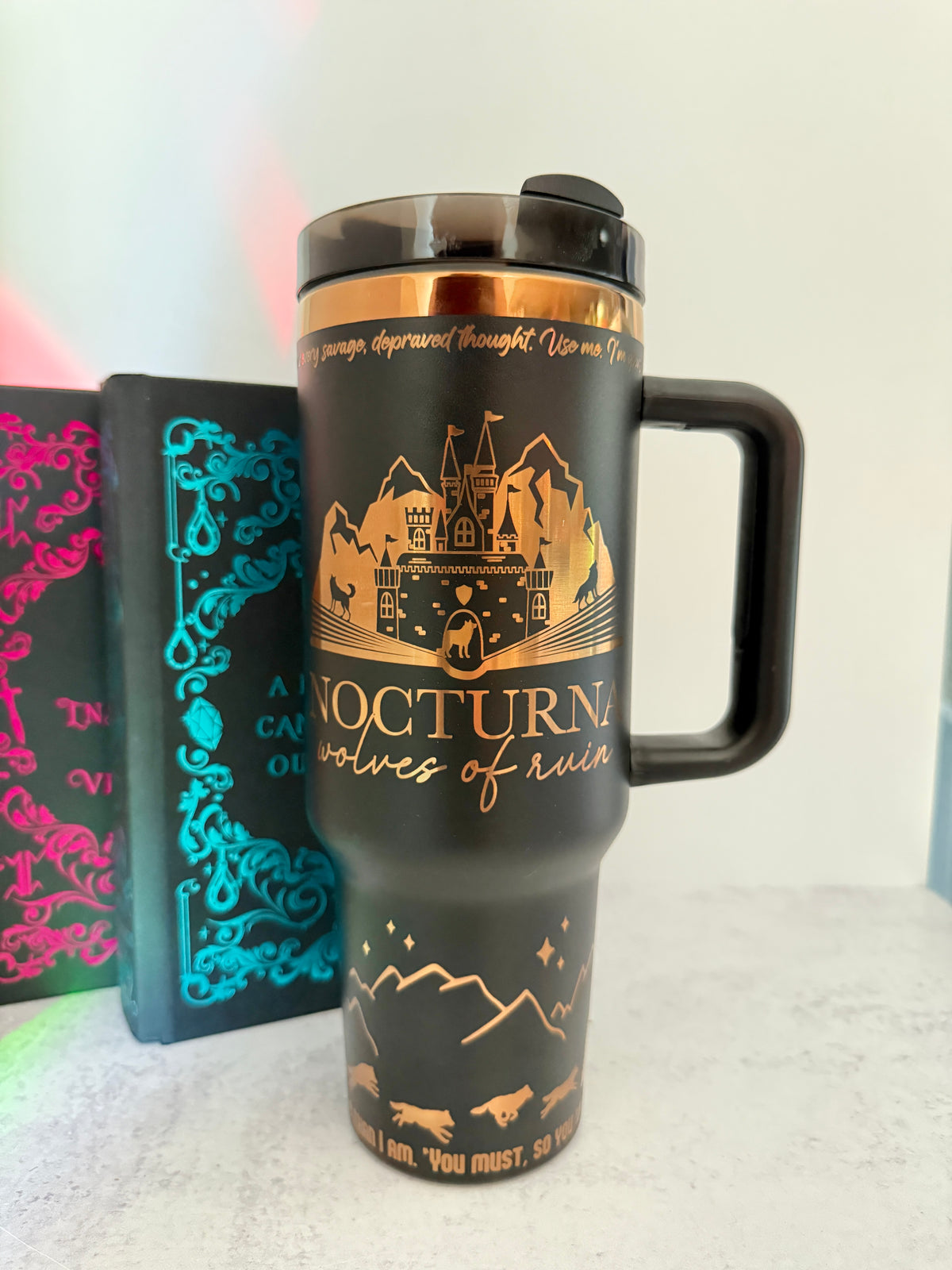 Black 40 oz Dire Bound inspired tumbler with a gold-engraved Nocturna castle, mountains, and wolves
