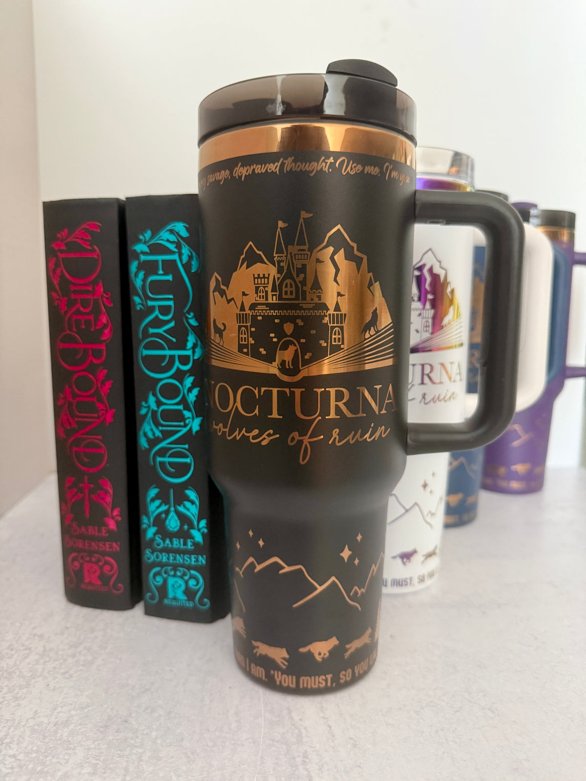 Black 40 oz Dire Bound inspired tumbler with a gold-engraved Nocturna castle, mountains, and wolves