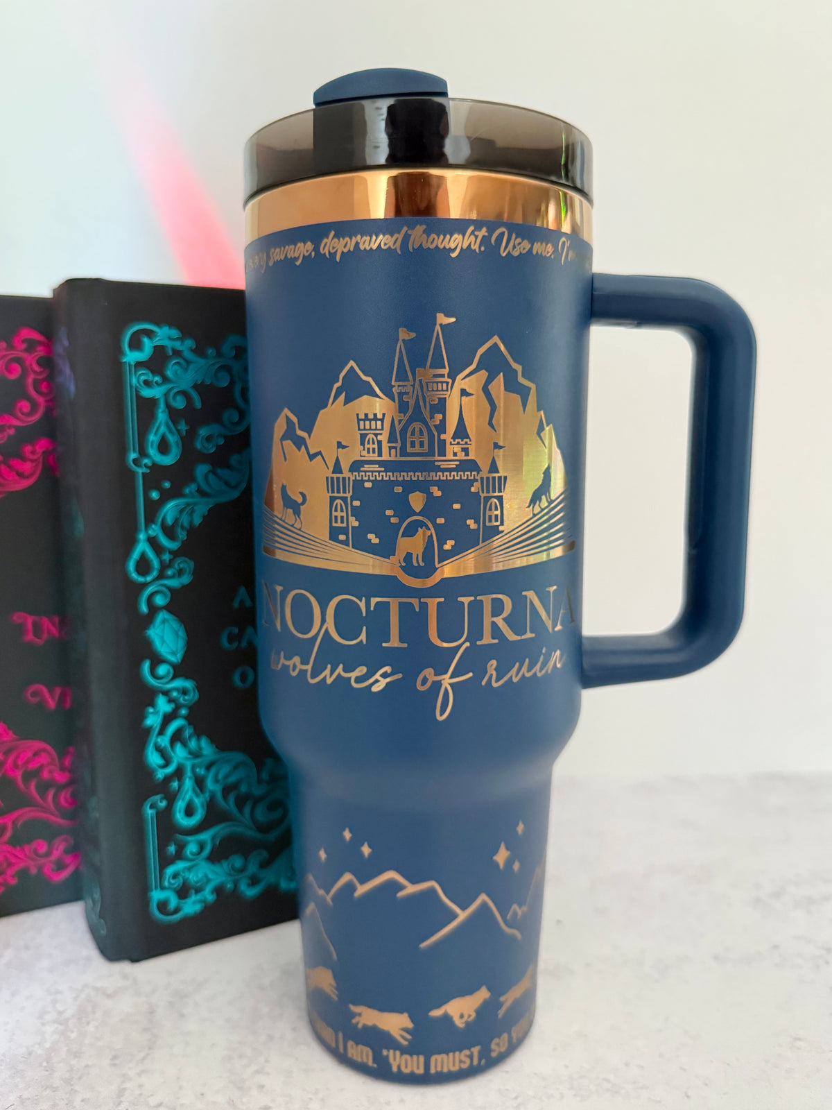 Blue 40 oz Dire Bound inspired tumbler with a gold-engraved Nocturna castle, mountains, and wolves