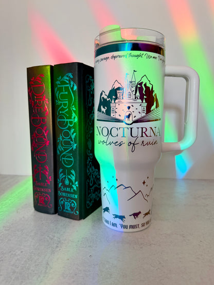White 40 oz Dire Bound inspired tumbler with a rainbow-engraved Nocturna castle, mountains, and wolves