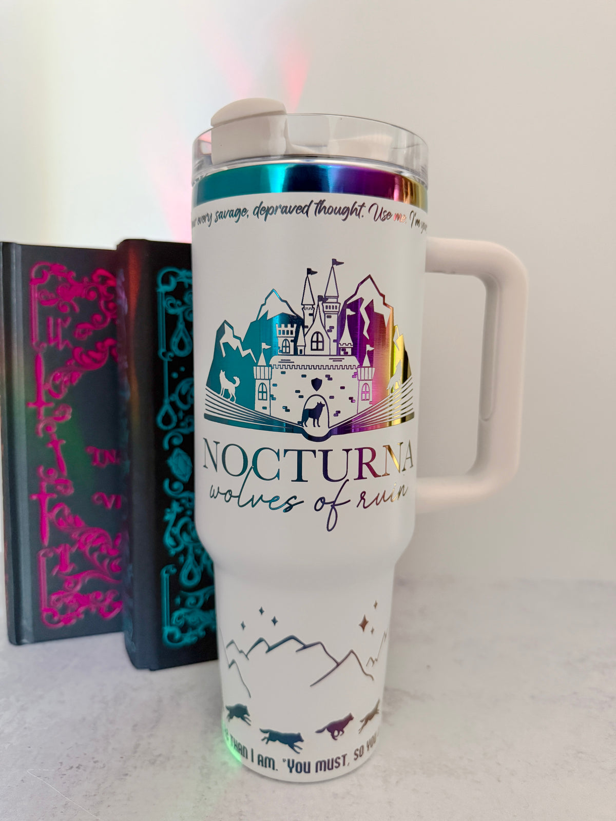 White 40 oz Dire Bound inspired tumbler with a rainbow-engraved Nocturna castle, mountains, and wolves