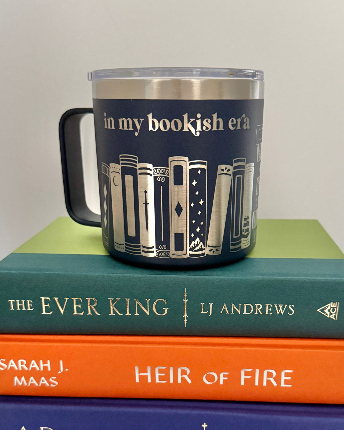 Mug with book design "in my bookish era" on top of stack of books