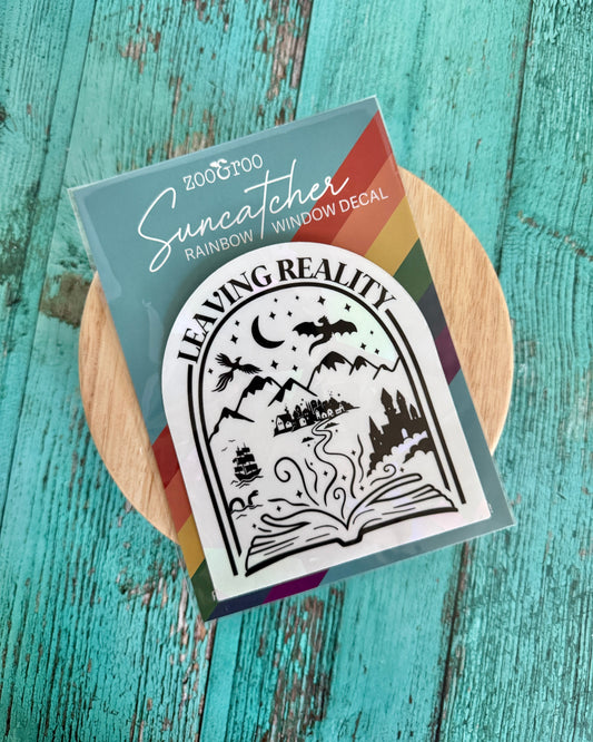Suncatcher window decal packaging on a wooden surface with a teal background