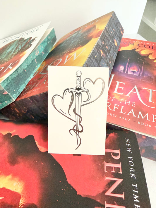 Mating mark temporary tattoo design showing two hearts forged into a dagger, displayed against Kindred's Curse Saga paperbacks