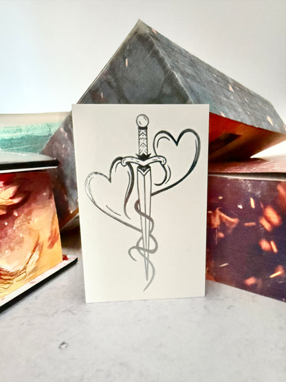 Two hearts forged into a dagger - the mating mark temporary tattoo leaning against the Kindred's Curse Saga books by Penn Cole
