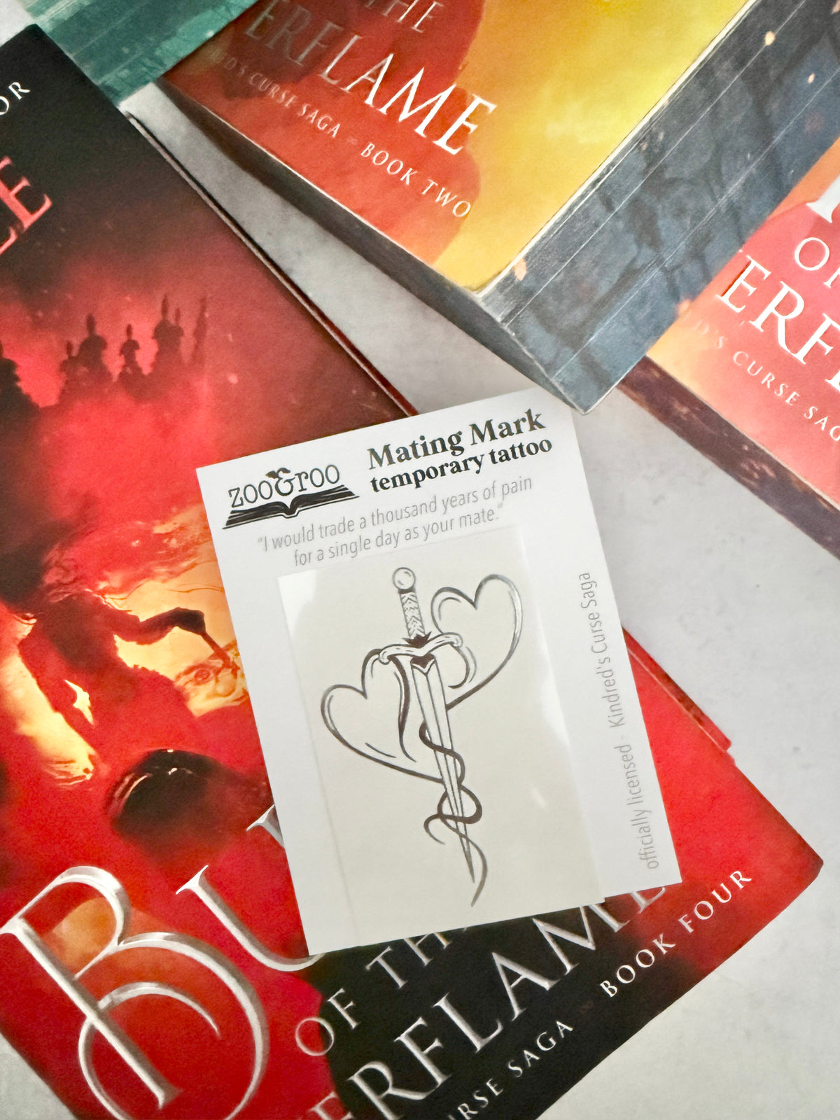 Two hearts forged into a dagger - the mating mark temporary tattoo resting on the cover of Burn of the Everflame by Penn Cole
