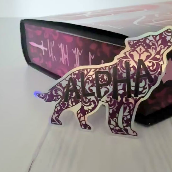 Holographic die cut wolf shaped sticker in a damask floral design with "alpha" in a bold font.