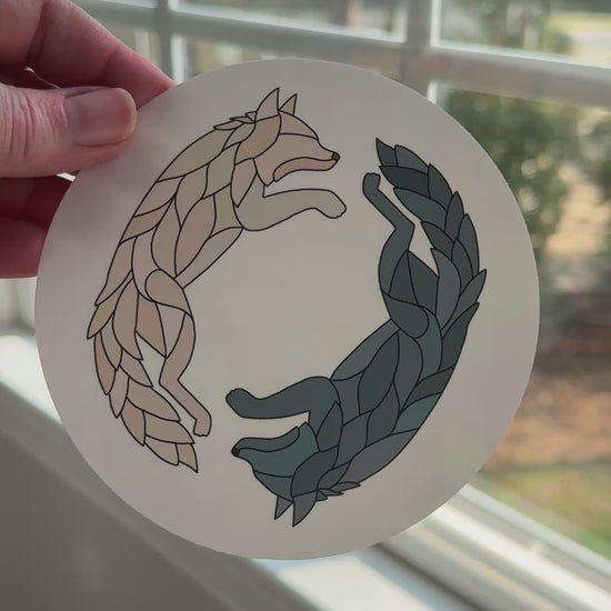 Video of a wolf decal being removed off a white backing to reveal the rainbow holographic colors