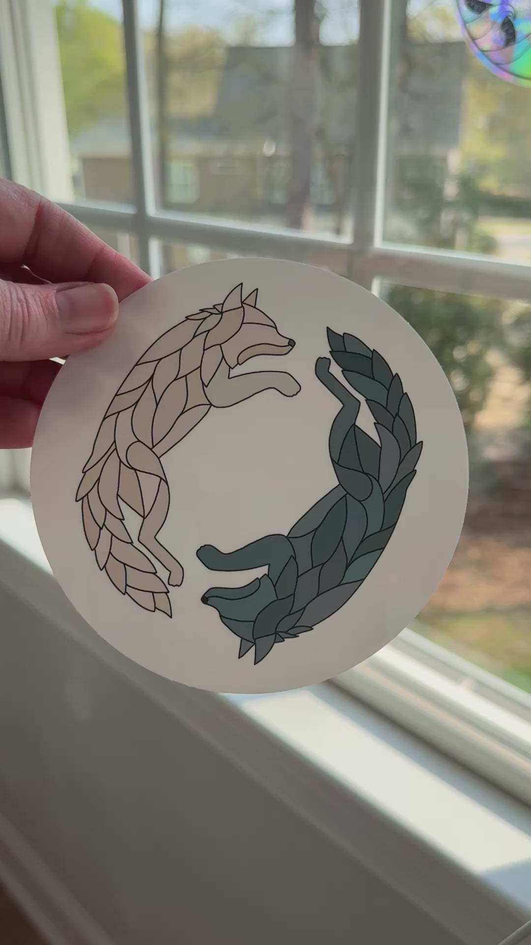 Video of a wolf decal being removed off a white backing to reveal the rainbow holographic colors