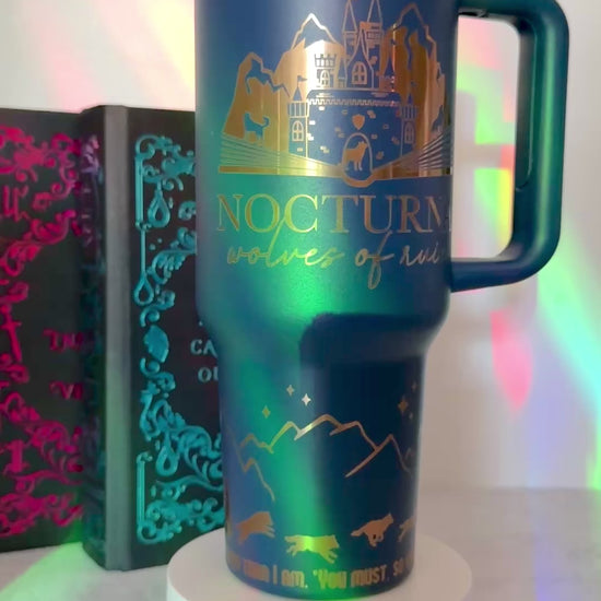 Blue 40 oz Dire Bound inspired tumbler with gold-engraved Nocturna castle, mountains, wolves and wolf pack symbols for Daemos, Strategos, Phylax and Kryptos