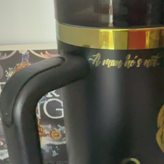 A black tumbler engraved with a rainbow quote from the Ever King by LJ Andrews: 'A man he's not. We work. We rot. No sleep until it's through. A sailor's grave is all we crave. We are the Ever King's crew.'