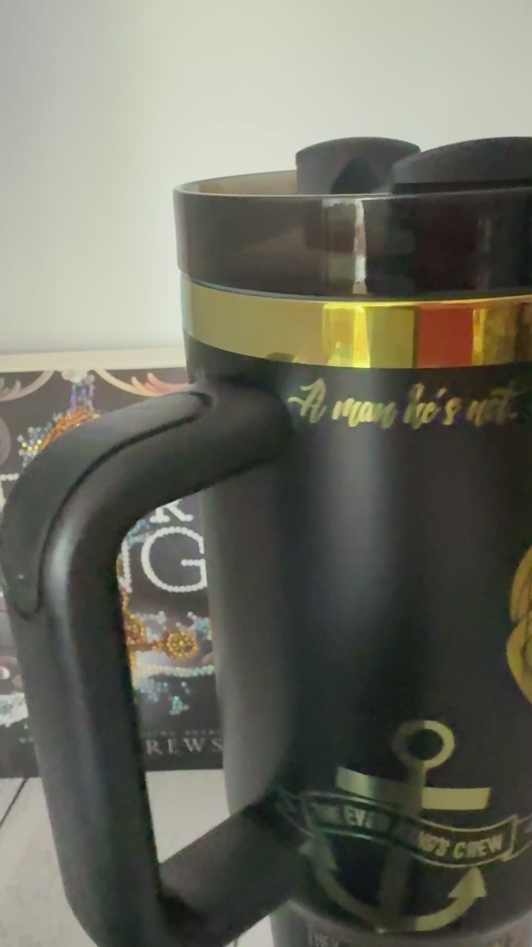 A black tumbler engraved with a rainbow quote from the Ever King by LJ Andrews: 'A man he's not. We work. We rot. No sleep until it's through. A sailor's grave is all we crave. We are the Ever King's crew.'