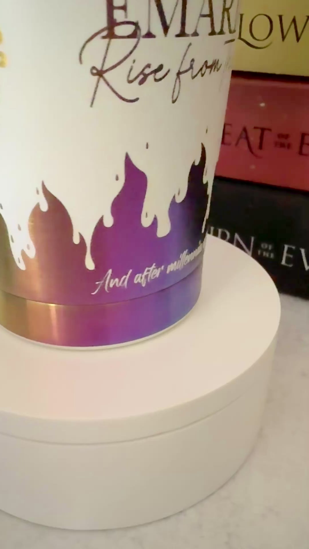 Slow turn of a white and rainbow iridescent 20 oz Emarion tumbler focusing on a quote from Burn of the Everflame by Penn Cole