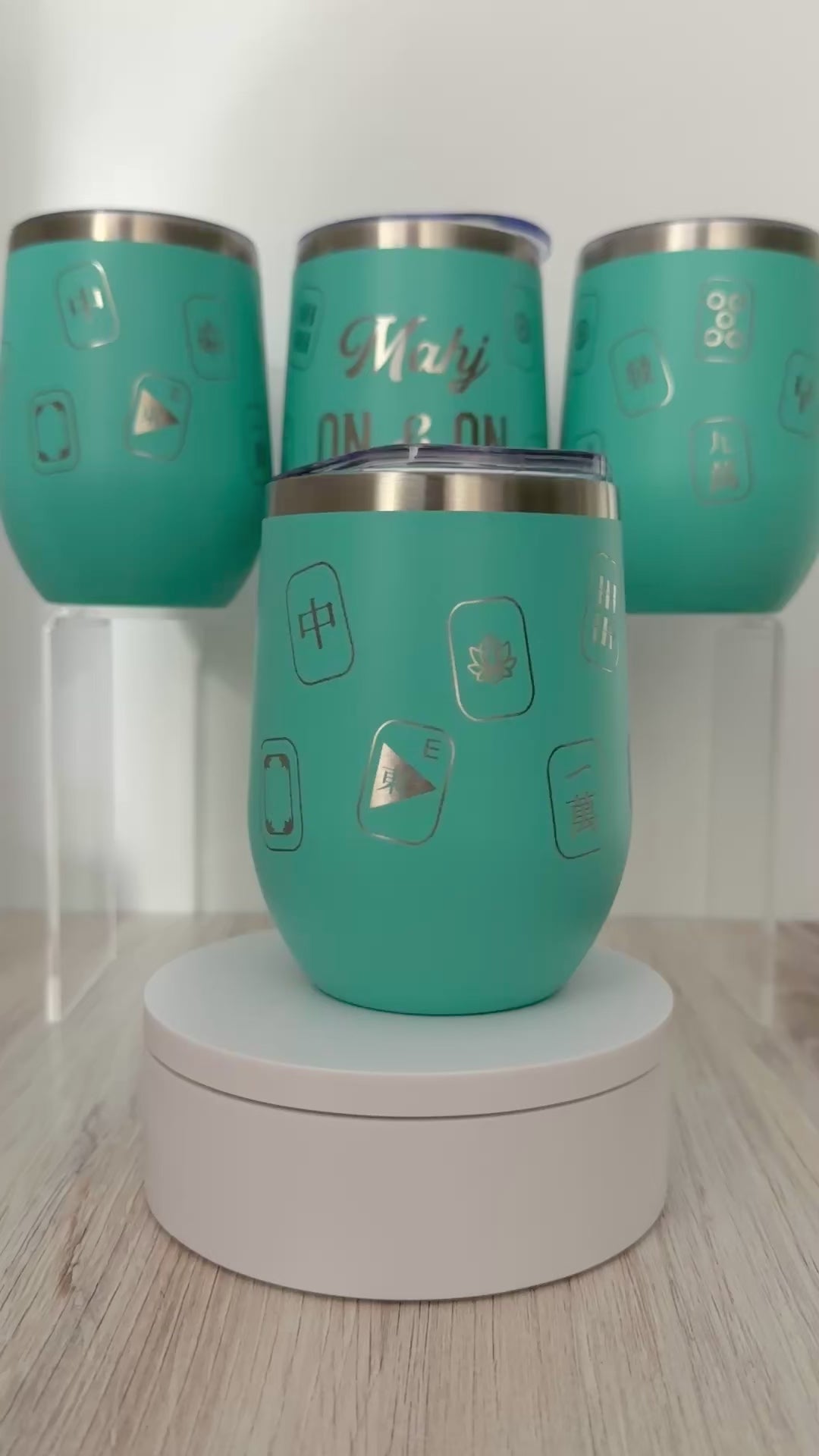Mahjong wine tumbler with 'mahj on and on' text and mahjong tiles wrapped around the aqua tumbler.