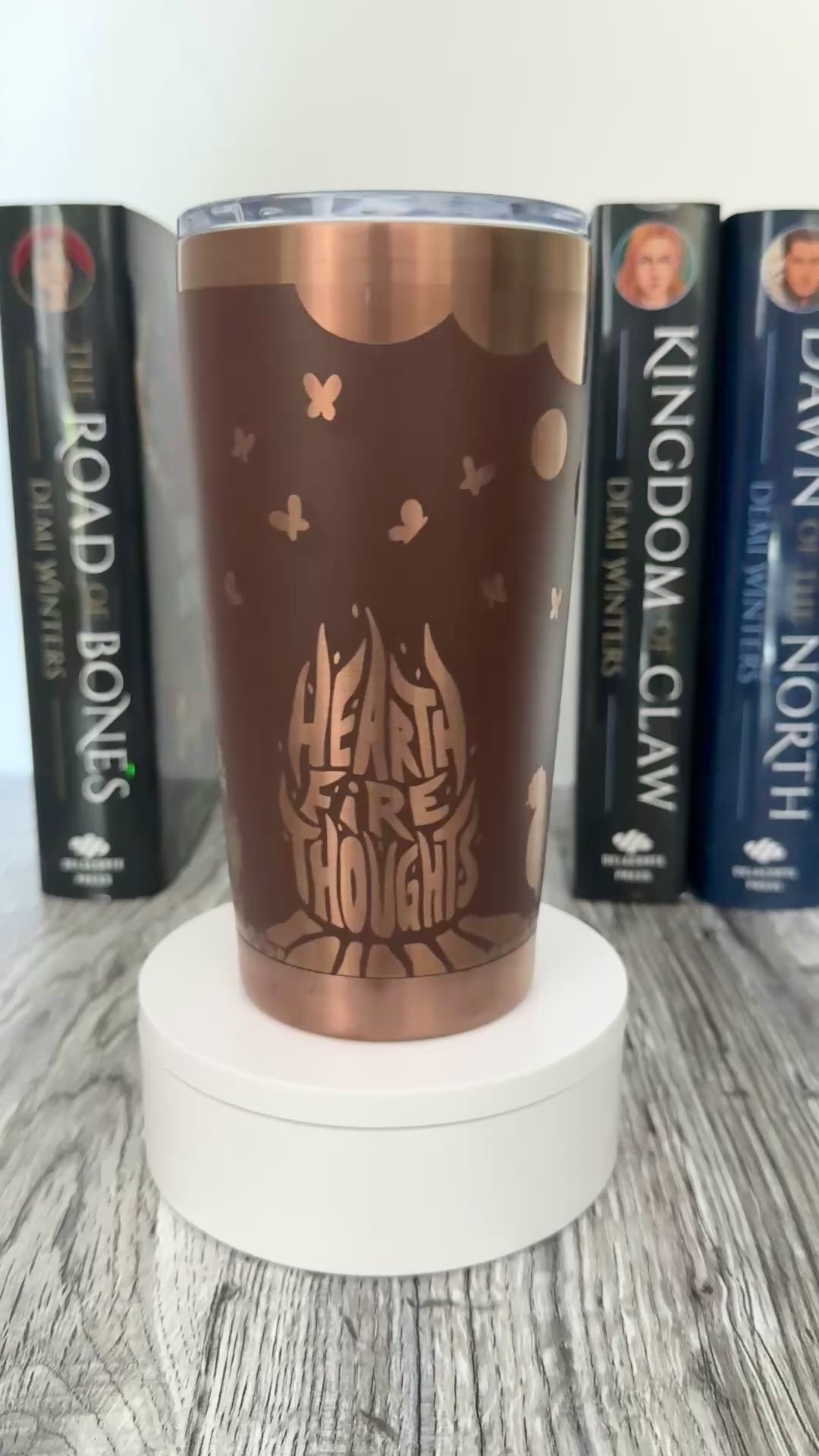 A brown and gold tumbler with 'Hearthfire Thoughts' design inspired by The Road of Bones Ashen series books by Demi Winters