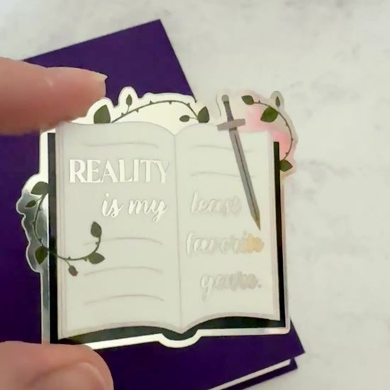 Video of the metallic Reality is my least favorite genre sticker tilting in the light to show the shifting finish