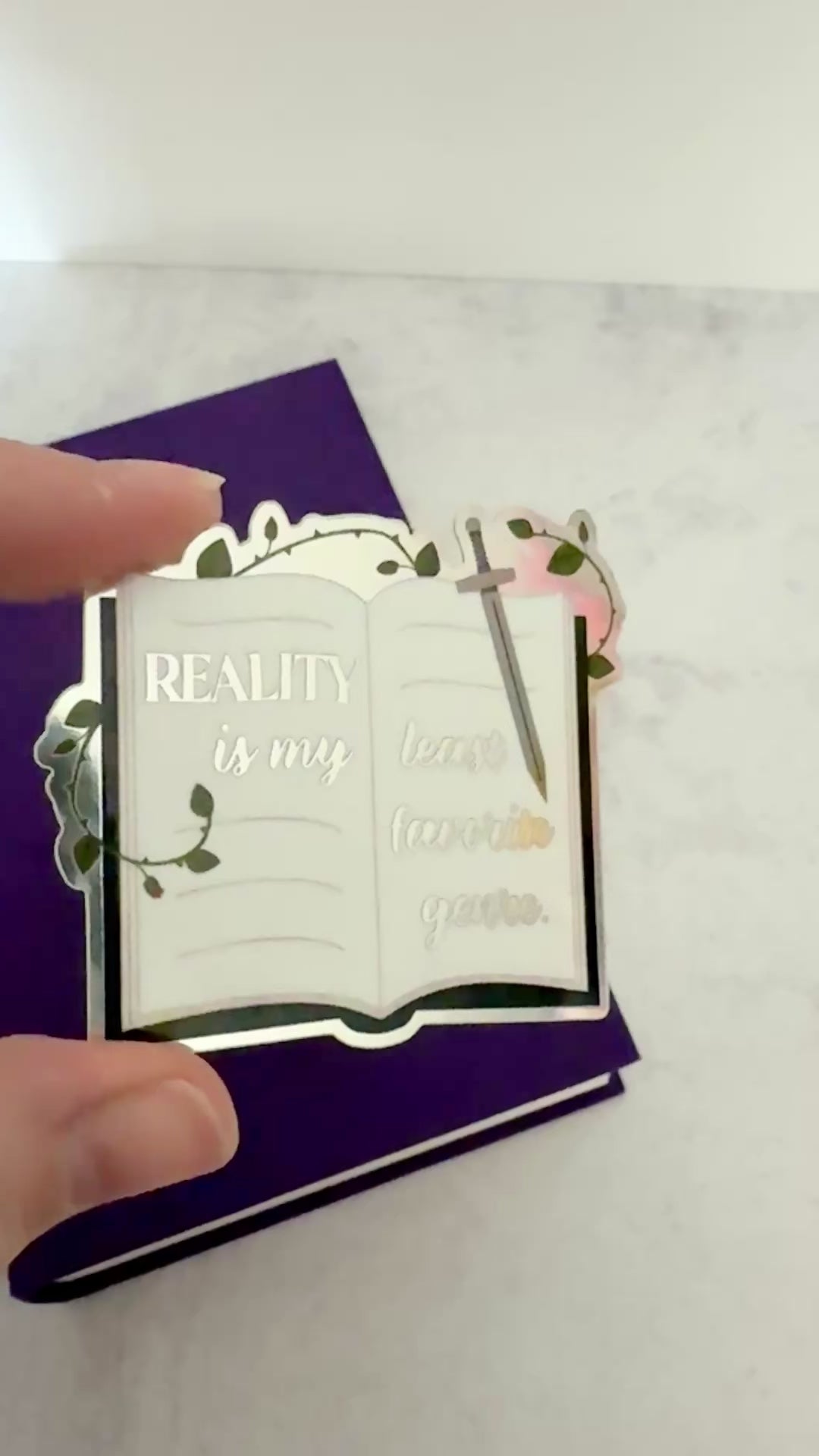 Video of the metallic Reality is my least favorite genre sticker tilting in the light to show the shifting finish