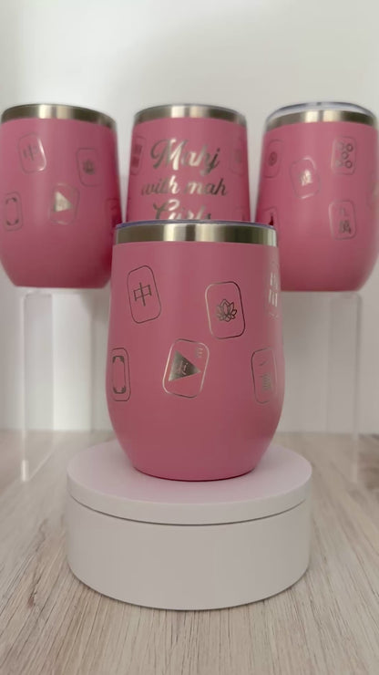 Mahjong wine tumbler with 'mahj with mah girls' text and mahjong tiles wrapped around the pink tumbler.