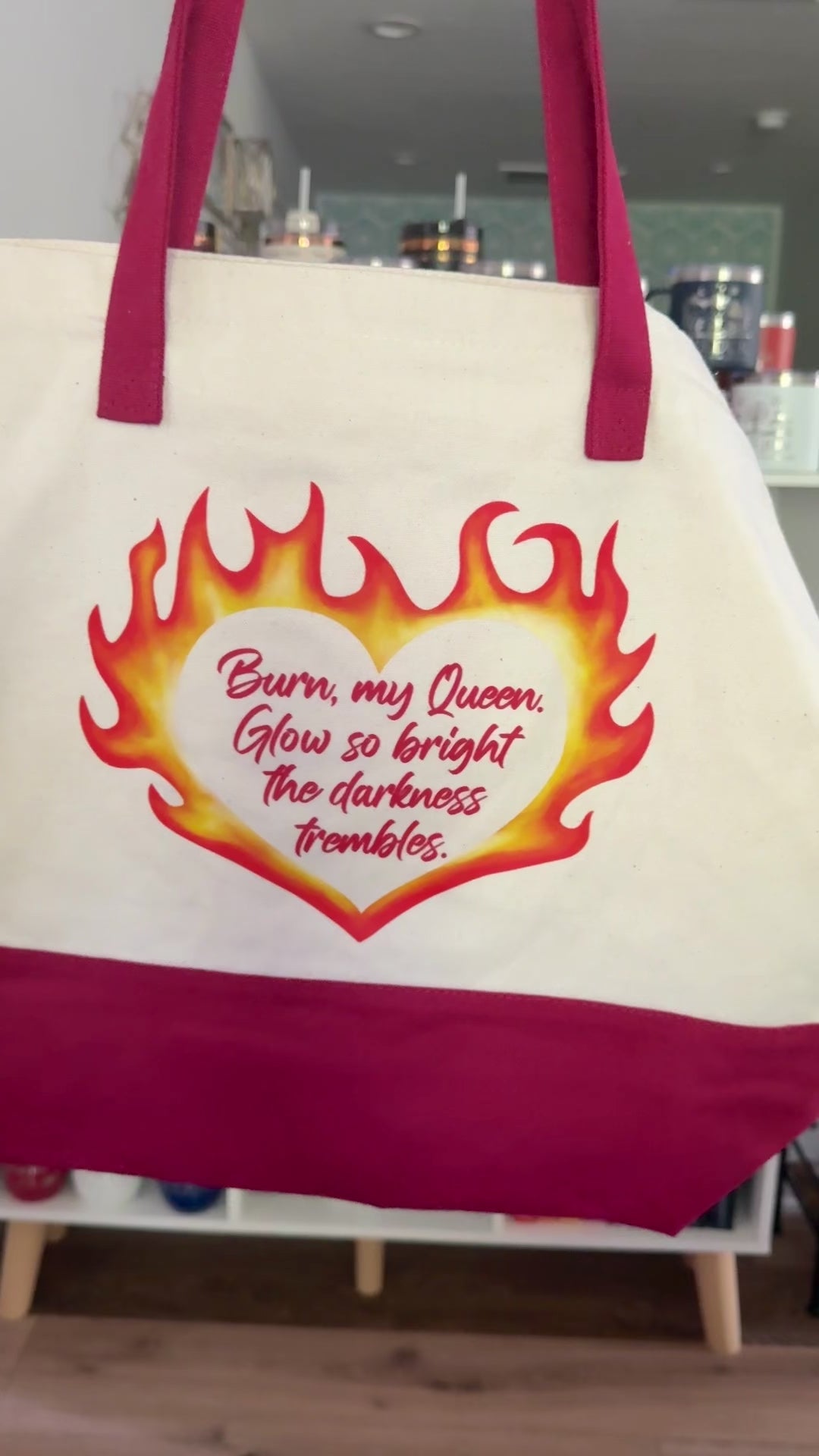 Tote bag inspired by The Kindred's Curse Saga by Penn Cole with a flaming heart design and quote "Burn my Queen. Glow so bright the darkness trembles" on one side and an original Emarion design with "rise from the ashes" on the other.