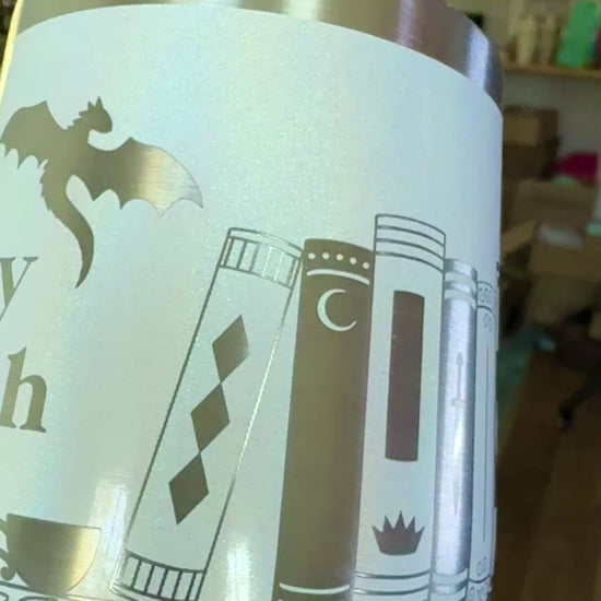 closeup view of a wine tumbler engraved with bookish design