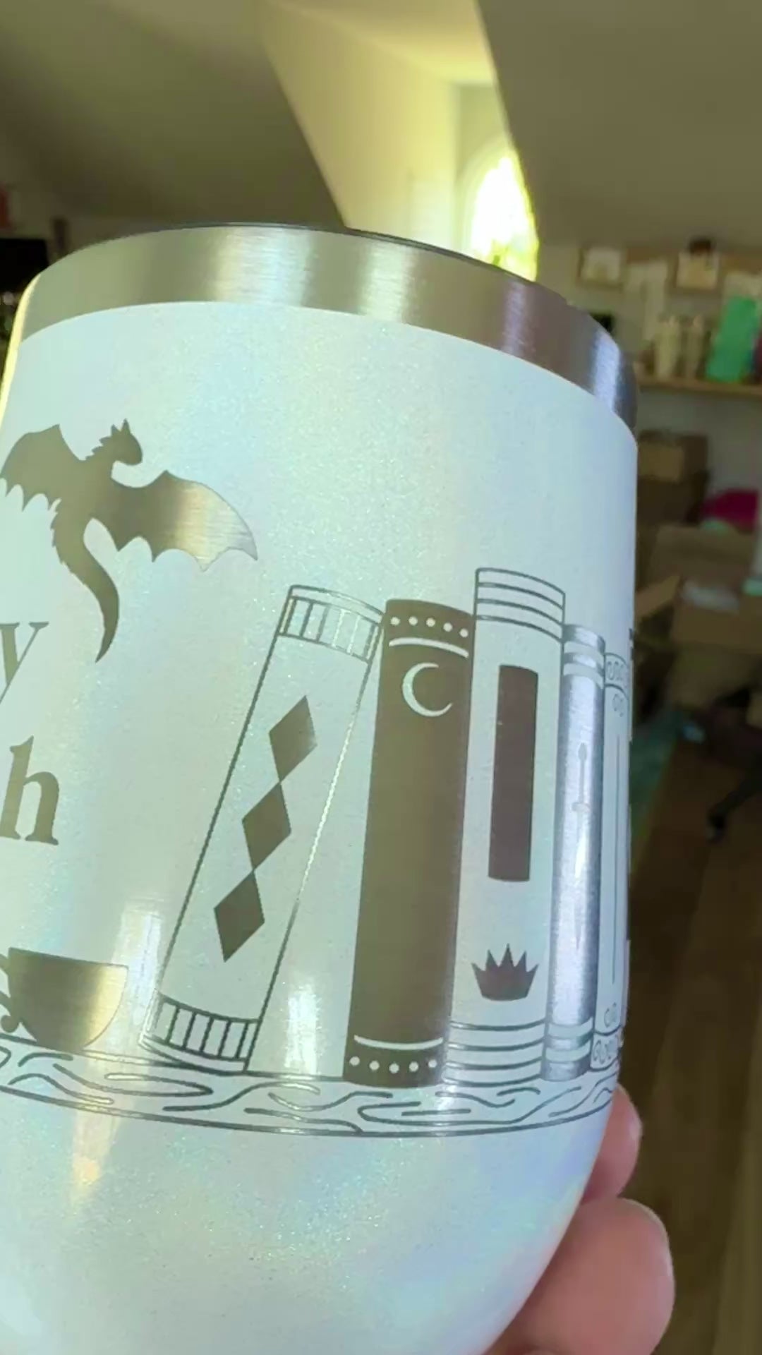 closeup view of a wine tumbler engraved with bookish design