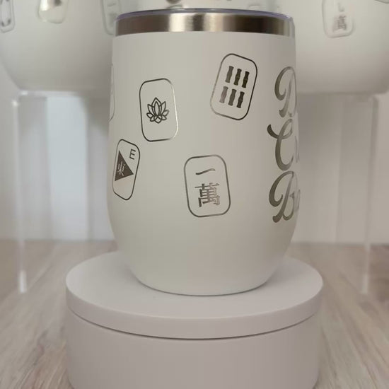 Mahjong wine tumbler with 'dot crak bam' text and mahjong tiles wrapped around the white tumbler.